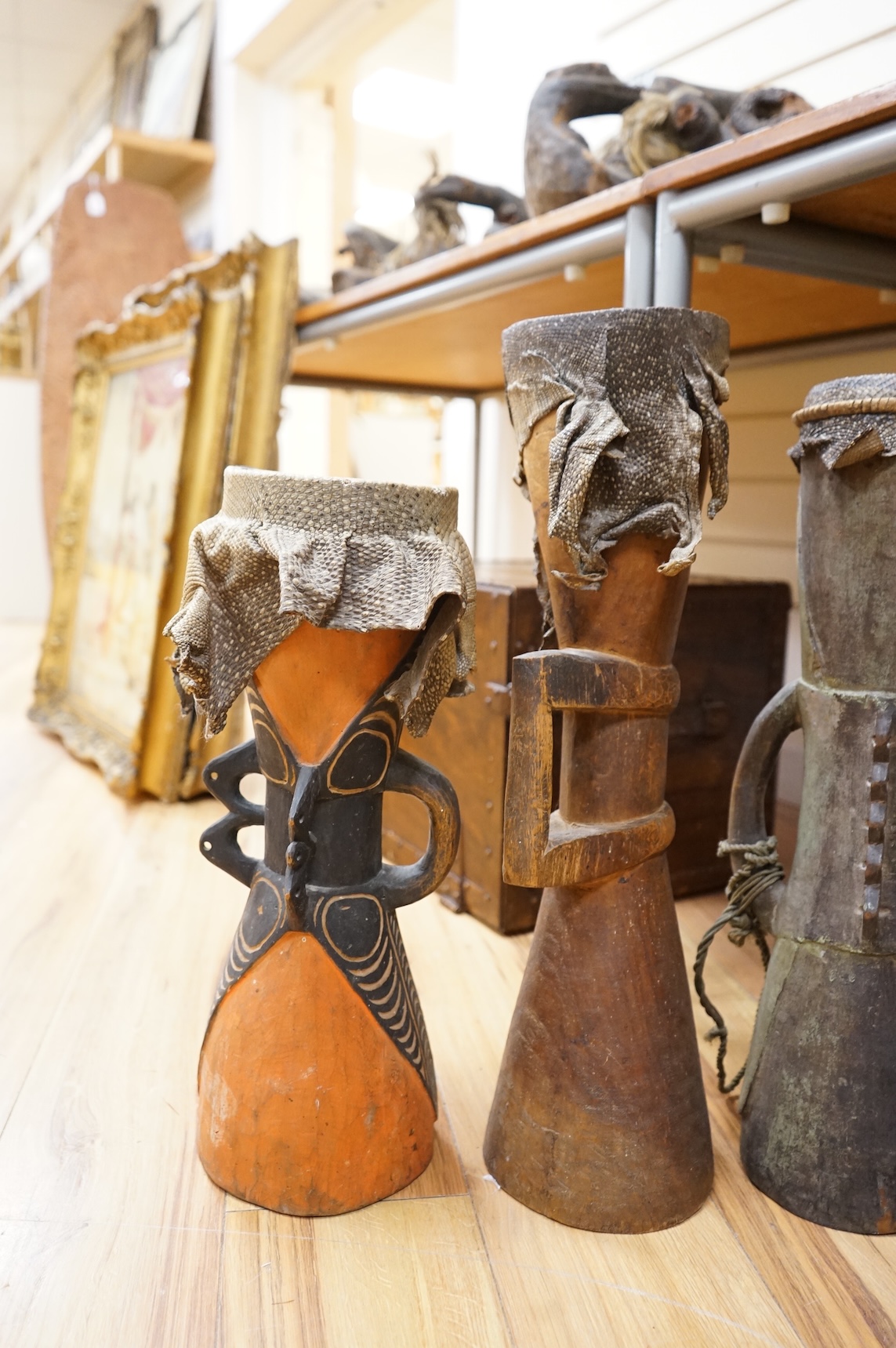 Six Papua New Guinea Sepik River Kundu wooden hand drums, of typical hour-glass form with skin tops, variously carved and incised with two painted, tallest 70cm